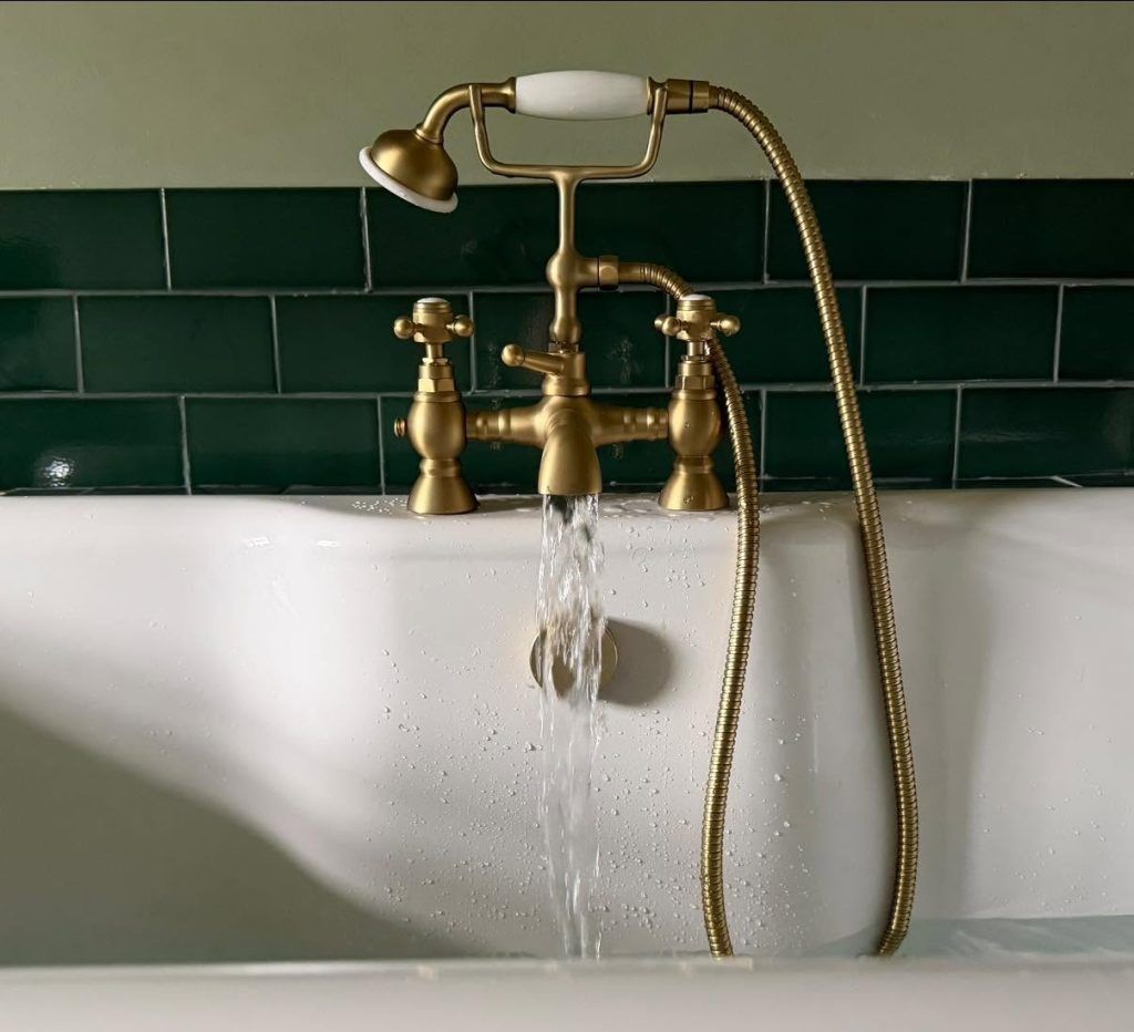 Bath taps and green wall tiles